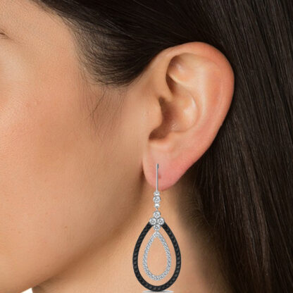 Close-up of black and white diamond teardrop earring worn on a model's ear