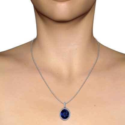 White gold sapphire diamond halo pendant worn on a model's neckline