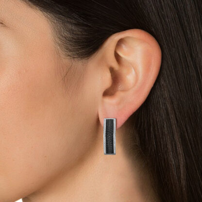 Close-up of wide black diamond hoop earring worn on a model's ear
