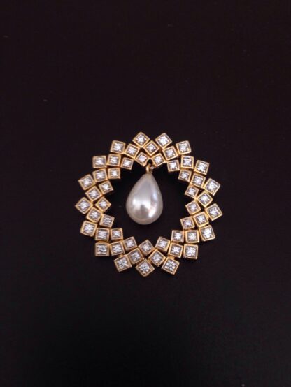 Close-up of yellow gold diamond tile pendant showing the dangling pearl