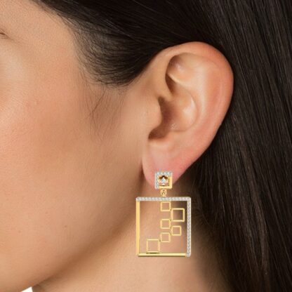 Yellow gold diamond dangle earrings, close-up