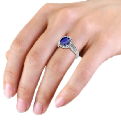 White gold cushion sapphire diamond halo ring worn on hand