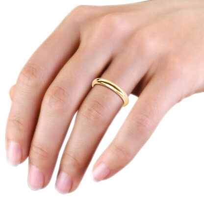 Yellow gold polished domed wedding band worn on the hand