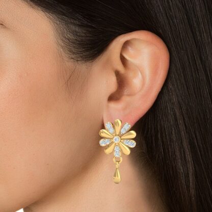 Close-up of yellow gold diamond flower stud earring worn on a model's ear