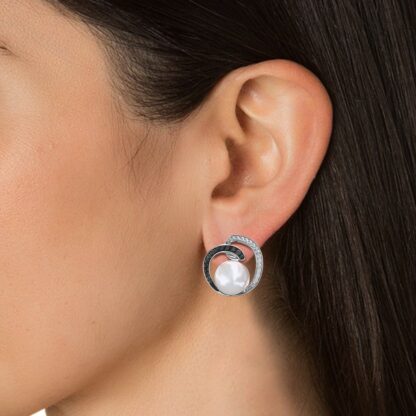 Close-up of black and white diamond pearl stud earring worn on a model's ear