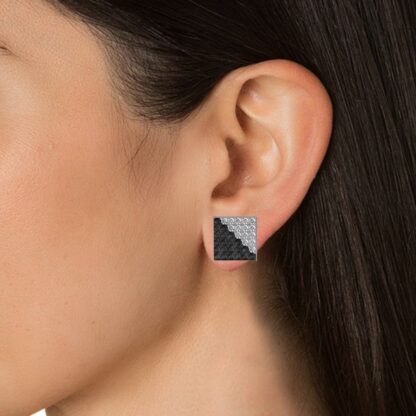 Close-up of black and white diamond square stud earring worn on a model's ear