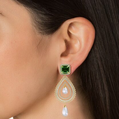 Close-up of emerald diamond pearl chandelier earring worn on a model's ear