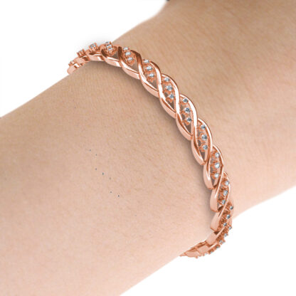 Rose gold twisted braid diamond bangle worn on the wrist
