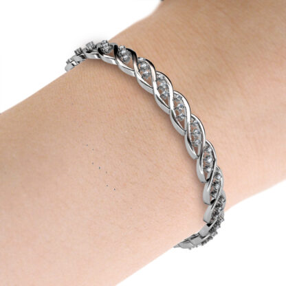 White gold or platinum twisted braid diamond bangle worn on the wrist